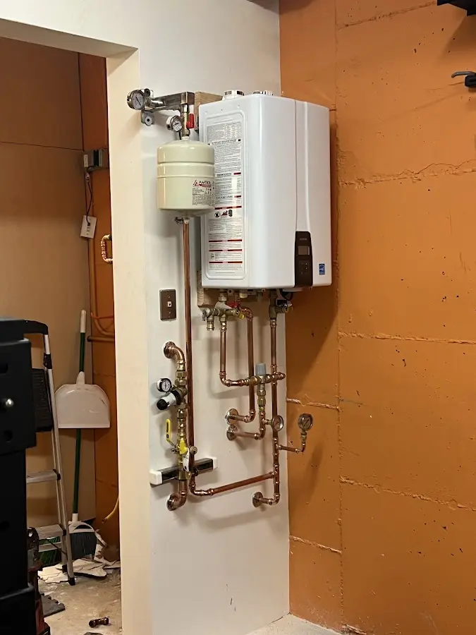 Plumbing technician inspecting water heater connections in Auburn